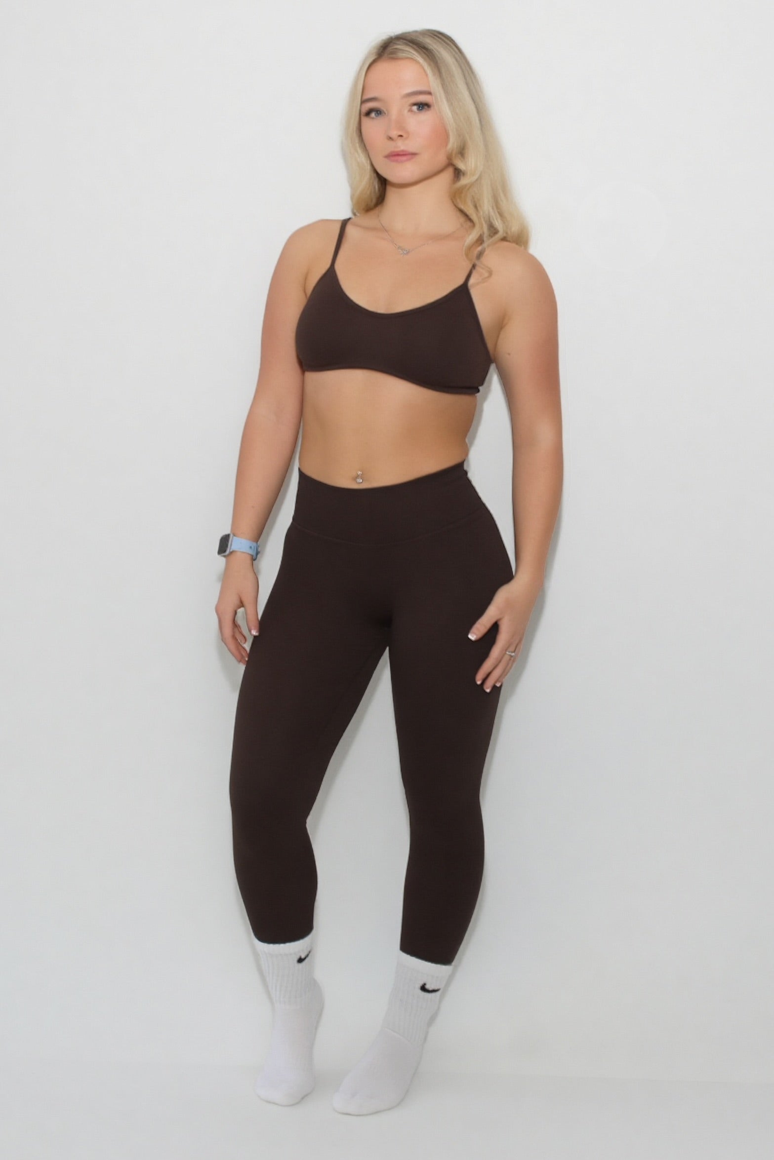 Young woman in The Eclipse Collection - Gym Bra, sports bra offering support and comfort, styled with matching leggings, ideal for workouts.