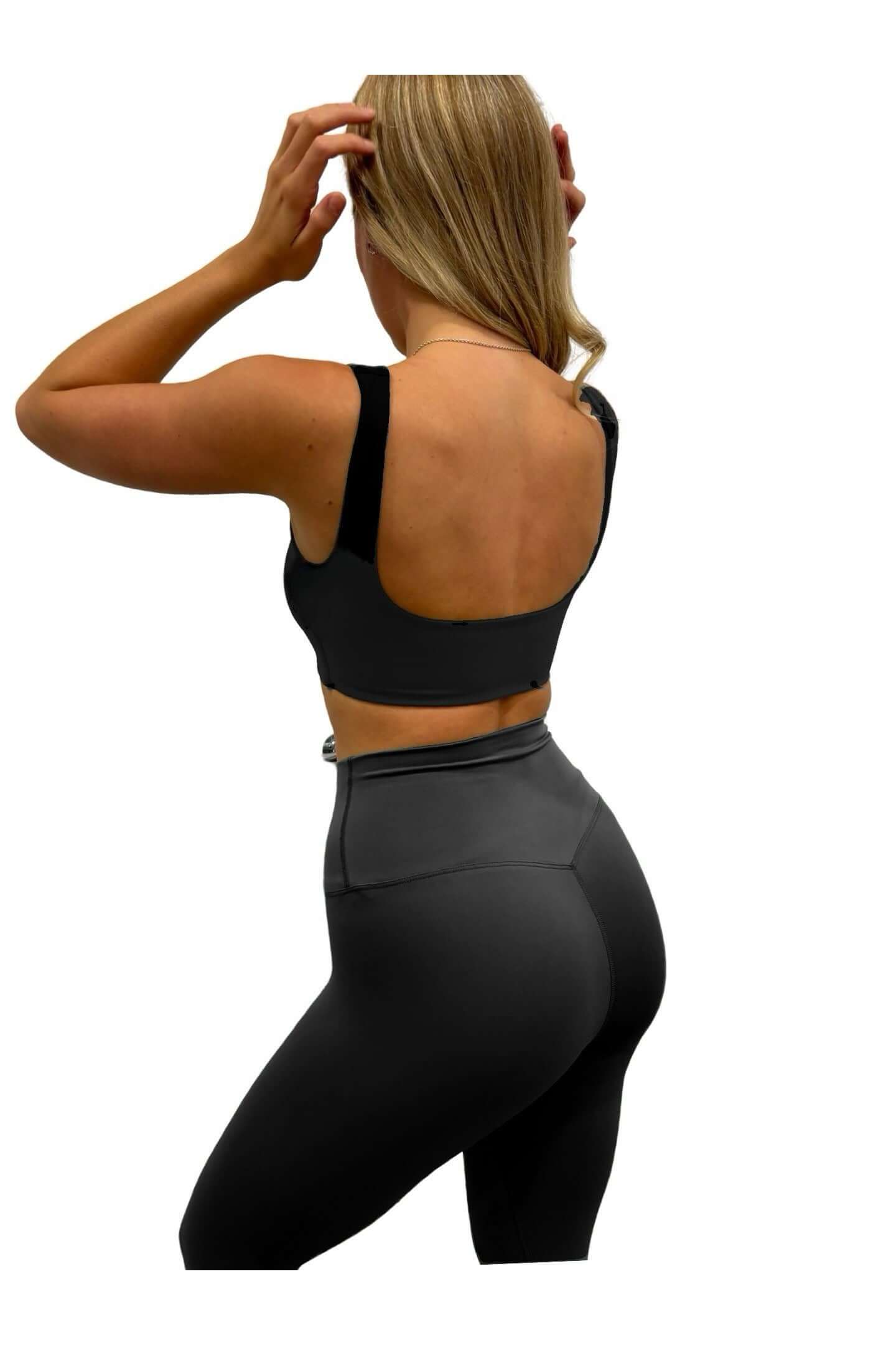 Woman wearing Pilates Reformer Collection in Black high-waisted wrap front gym leggings, showcasing a stylish and supportive fit for workouts.