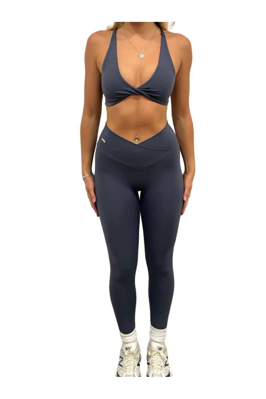 Woman wearing Pilates Reformer Collection high-waisted wrap front leggings, paired with white tennis shoes, showcasing a stylish and supportive gym outfit.