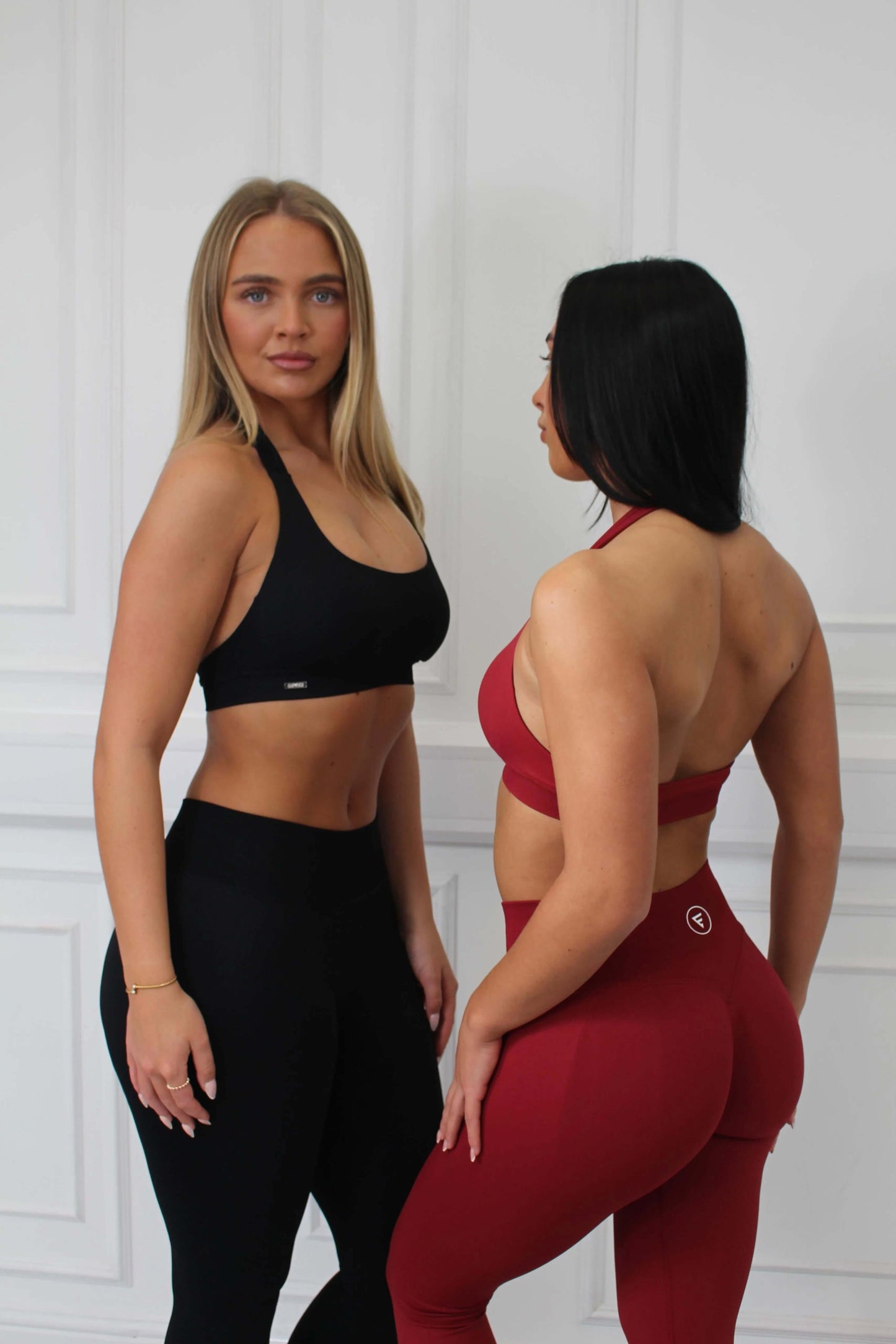 Two women model The Empower Edge Collection - Scrunch Bum Gym Leggings, showcasing the flattering design and athletic fit with high-waisted leggings and coordinating sports bras.