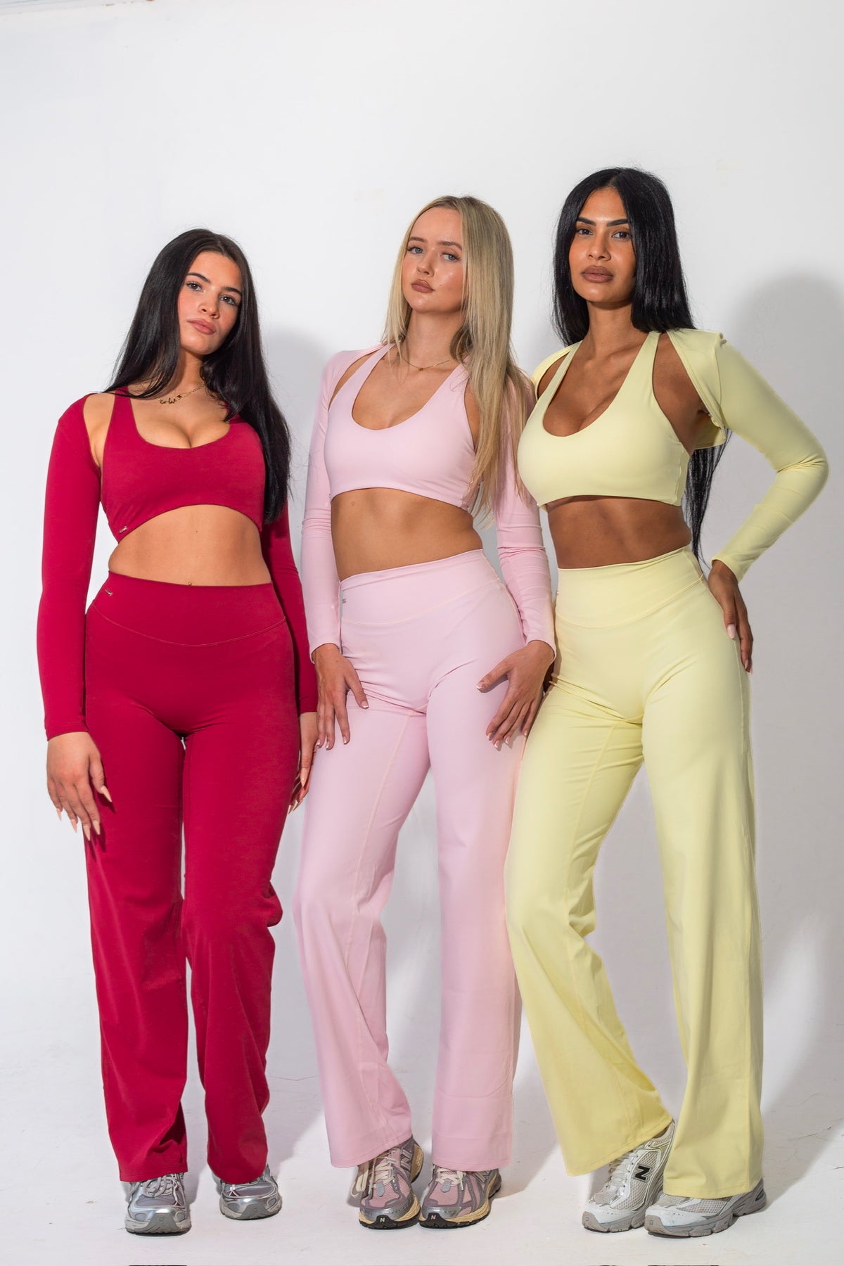 Three women wearing red pink and lemon Elena gym wear