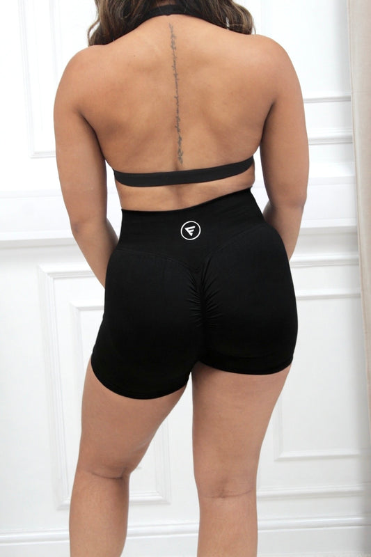 Person wearing The Ilume Collection Scrunch Bum Gym Shorts, showcasing a flattering fit and high waistband, with circular logo on the back.