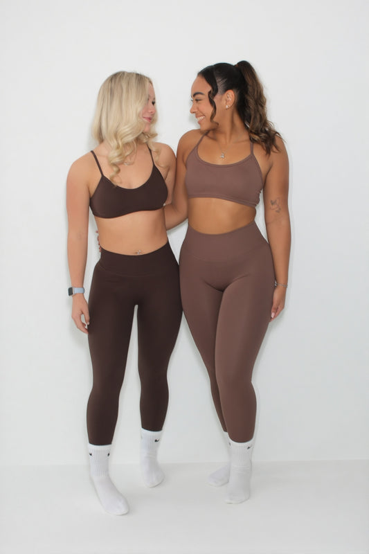 Two women in fitted activewear, showcasing Any 1 item for £25 offer. They're smiling, highlighting the apparel's comfort and style, perfect for casual workouts.
