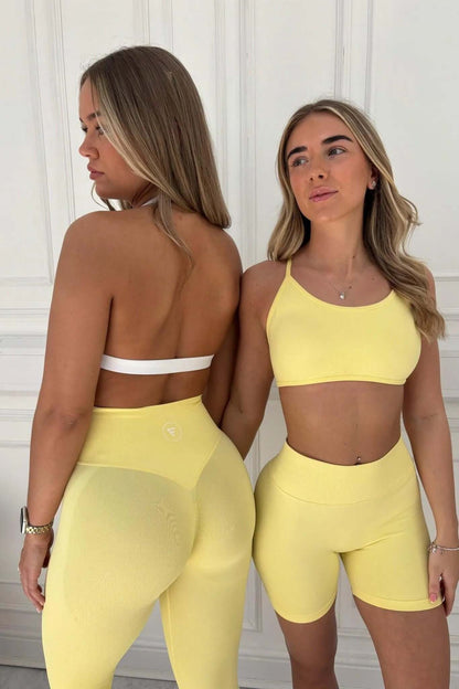Two women model The Ilume Collection - Scrunch Bum Gym Leggings, showcasing high-waist leggings and matching sports bras, emphasizing style and curve-enhancing design.