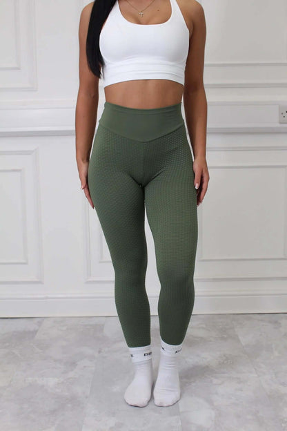 Person wearing Nova Honeycomb Scrunch Collection - Scrunch Bum Gym Leggings, showcasing the textured olive-green design and flattering fit, paired with a white crop top and socks.