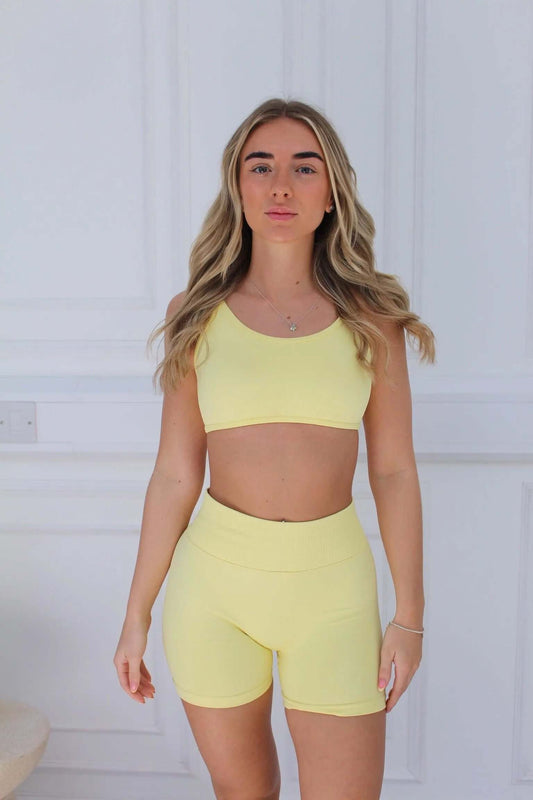 Young woman in lemon-yellow Ilume Collection Adjustable Cross Back Sports Bra, showcasing adjustable straps and cross back design for comfort and support.