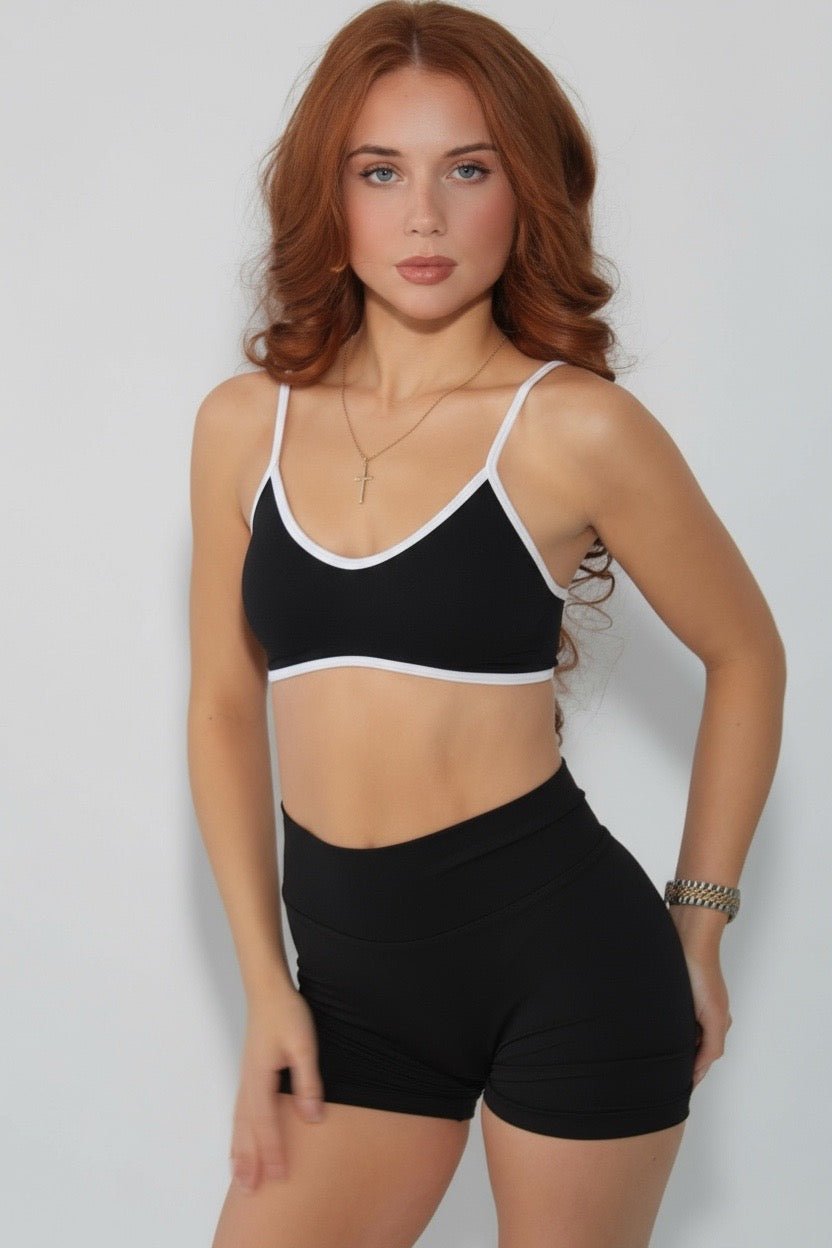 A young woman wears black Eclipse Collection Scrunch Bum Gym Shorts. They have a high-rise waistband.